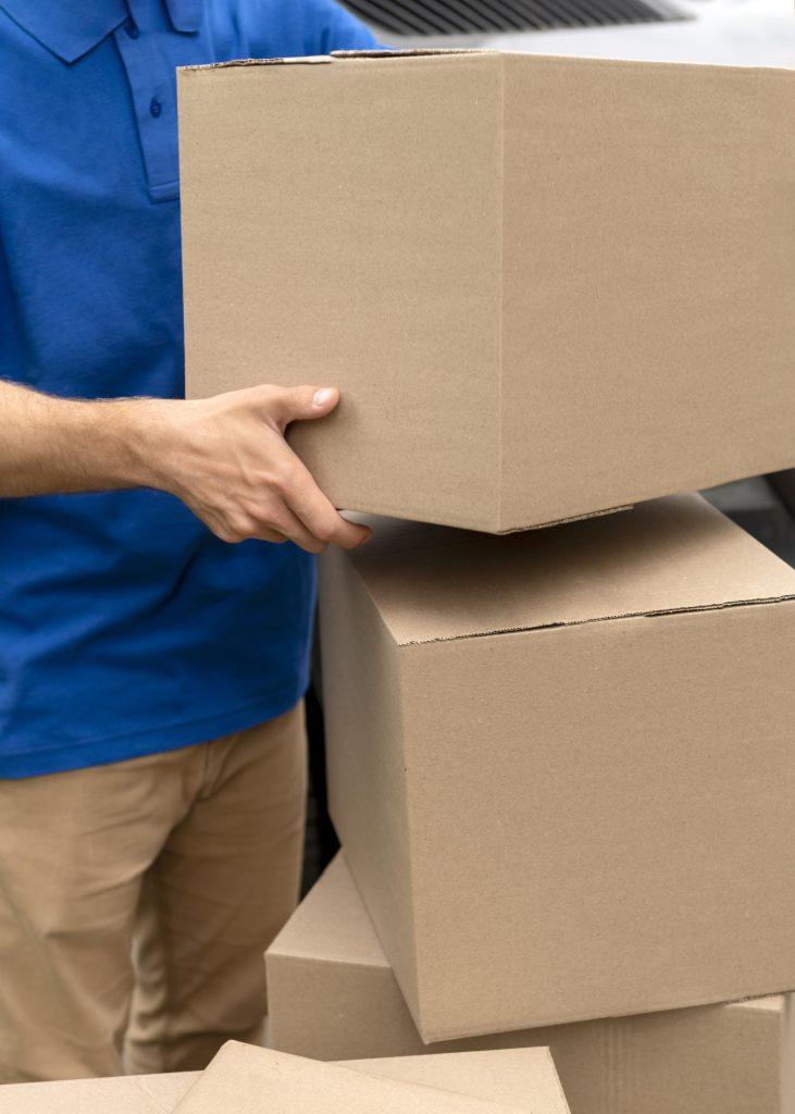 Hombre cargando cajas de cartón para entrega de importaciones.